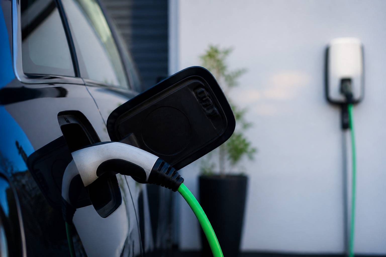 Connecteur inséré dans la trappe de recharge d'une voiture hybride