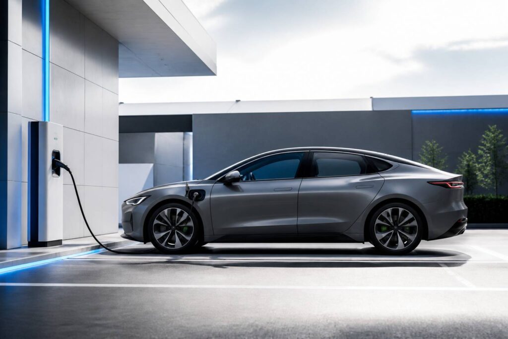 Voiture électrique fastback profilée branchée à une borne de recharge